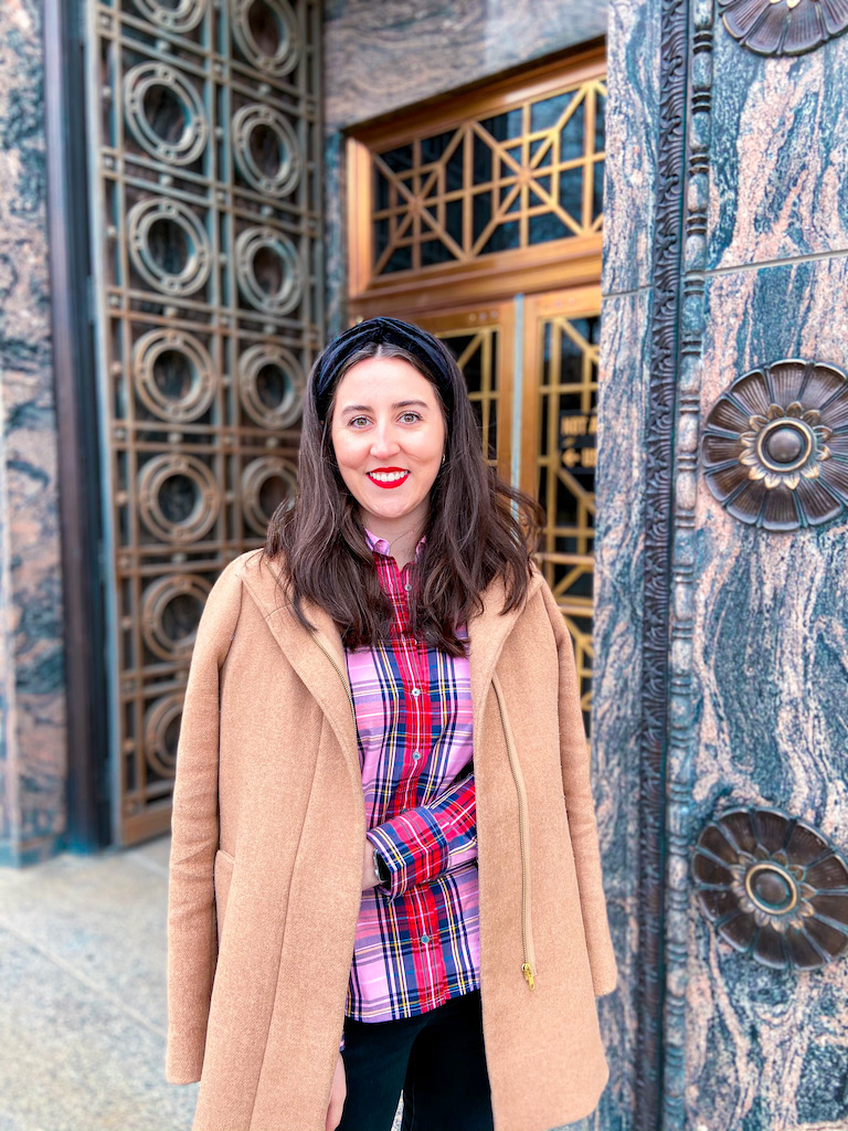 J. Crew pink tartan button down shirt, camel coat, black velvet headband, red lipstick