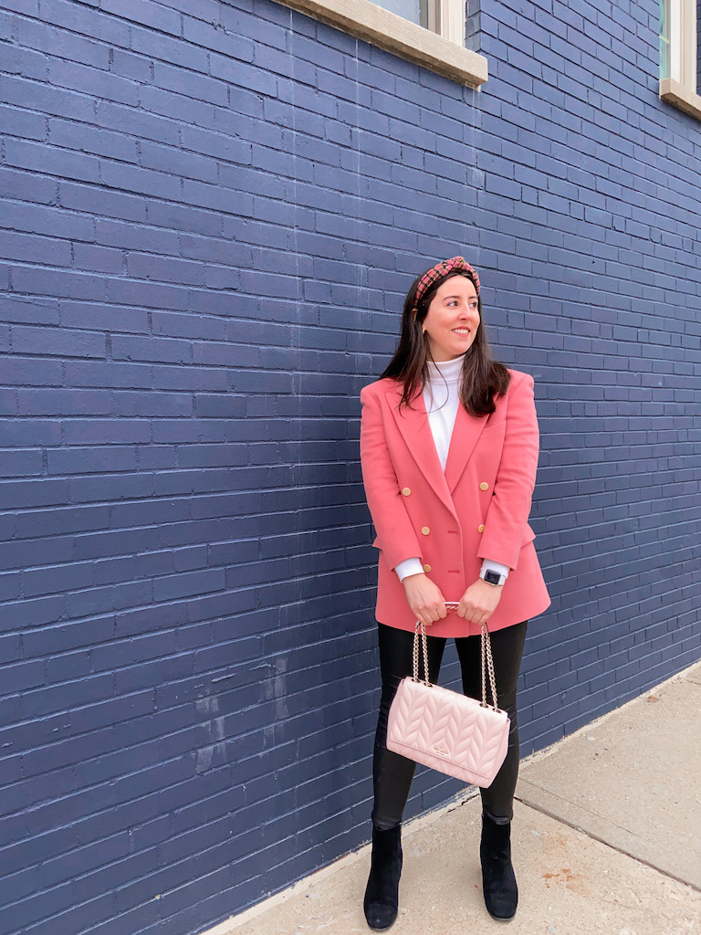 Styling the Pink Blazer of My Dreams (It's Thrifted!). This outfit consists of a pink double-breasted blazer, a white turtleneck, black faux leather pants, black booties, a plaid tweed headband, and a pink cross body convertible purse.