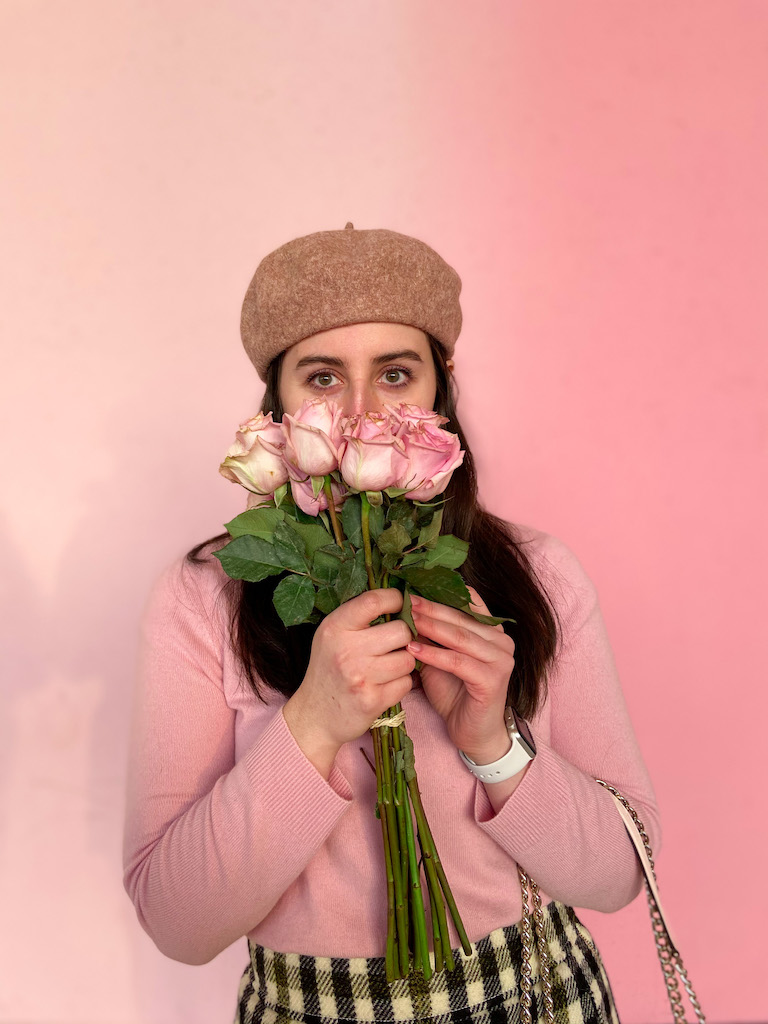 Image description: Parisian-Inspired Valentine's Day look. A wool beret, pink cashmere sweater, and gingham skirt.